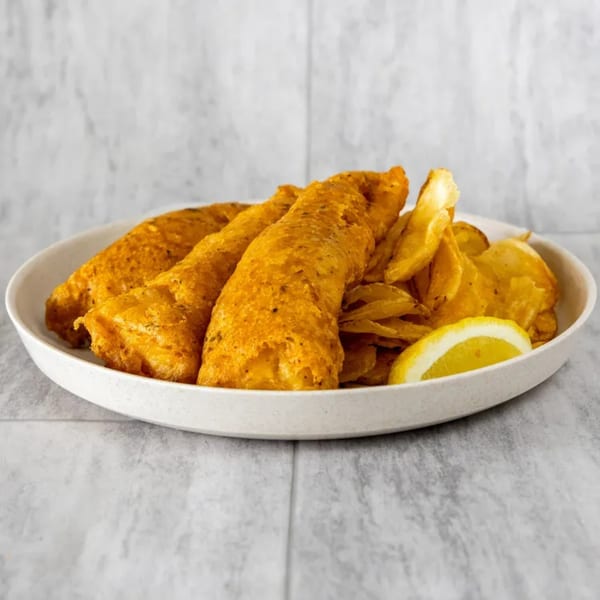 Three pieces of golden-fried fish and a pile of chips with a lemon wedge on a white plate.